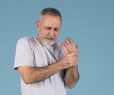 portrait senior man holding his injured wrist